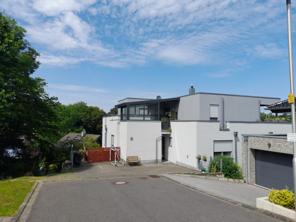 Fertiggestellte Estate Eingangsüberdachung aus Aluminium und Glas über dem Treppenaufgang eines Wohnhauses in Herzogenrath