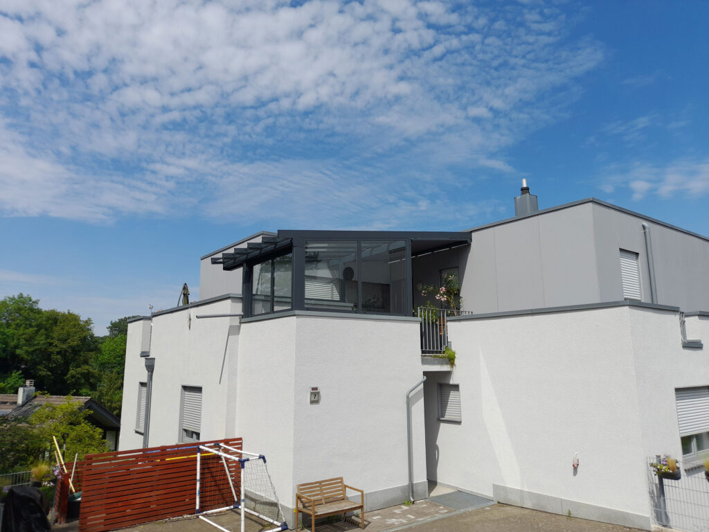 Darstellung der umgesetzten Estate Treppenaufgang-Überdachung aus Aluminium und Glas an einem modernen Wohnhaus